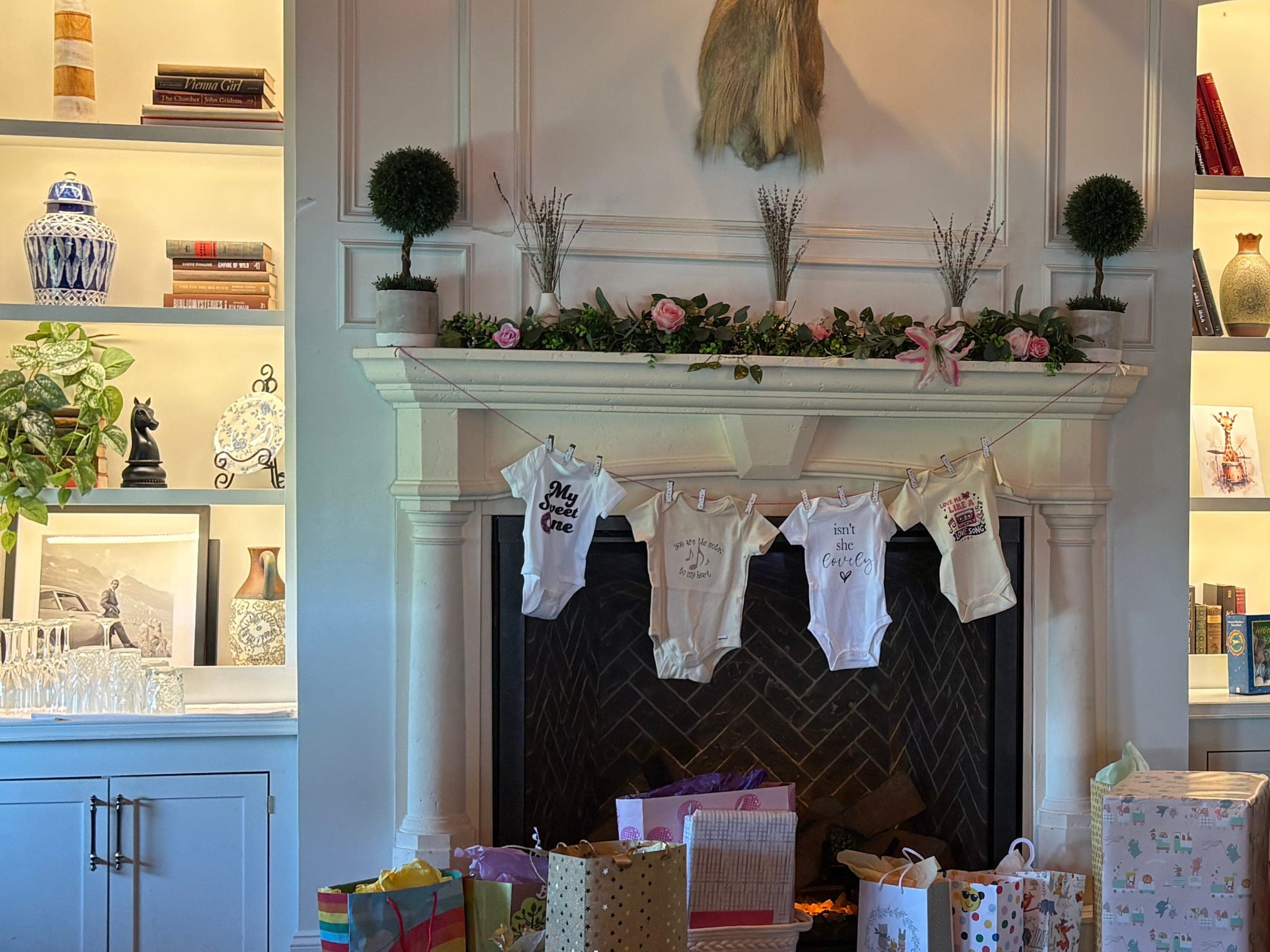 A garland of baby onesies strung across the fireplace above the gift table in The Library at Crown Tavern in Glen Mills, PA