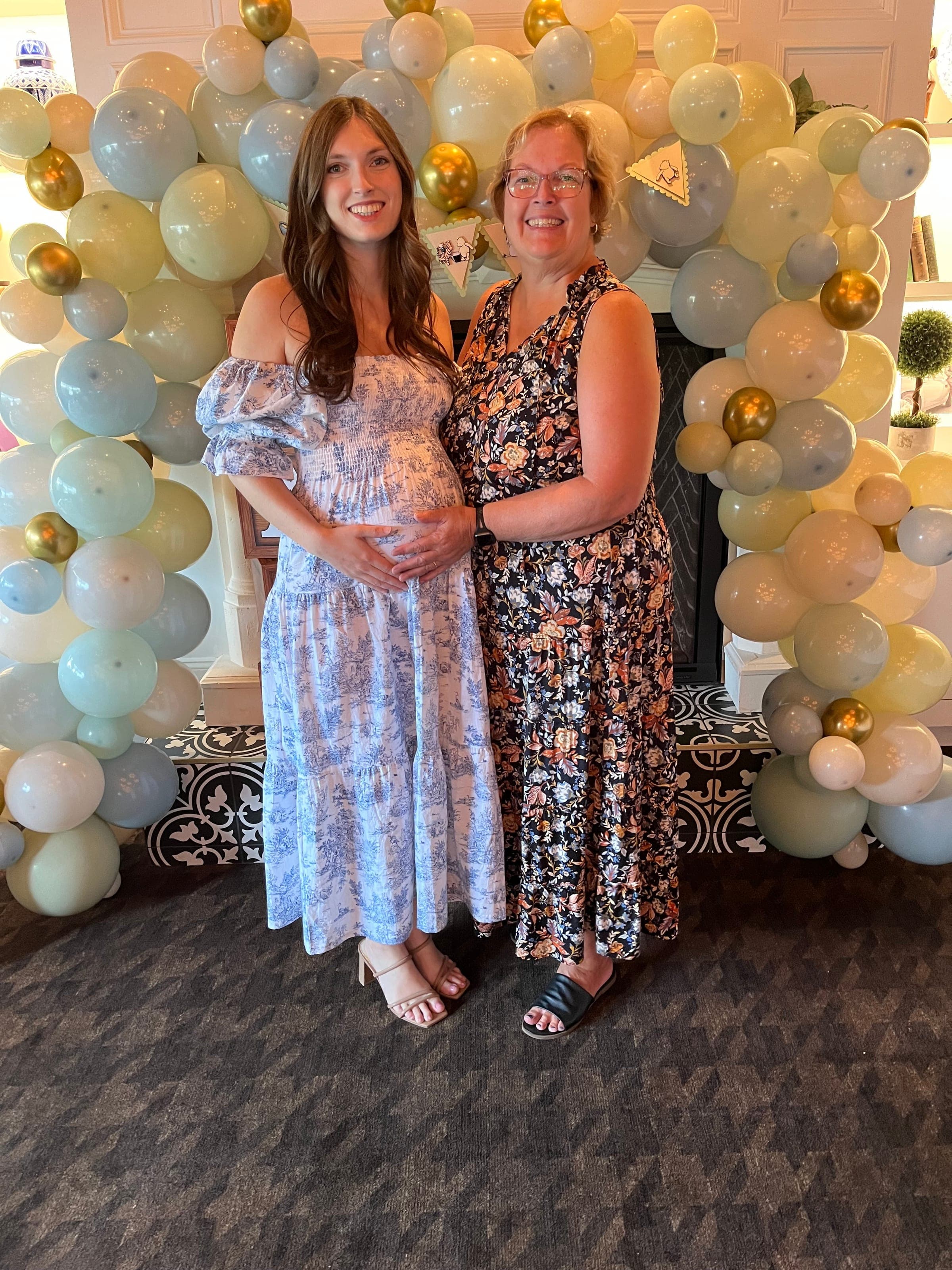 A mom-to-be under a balloon arch at her baby shower in The Library at Crown Tavern in Glen Mills, PA