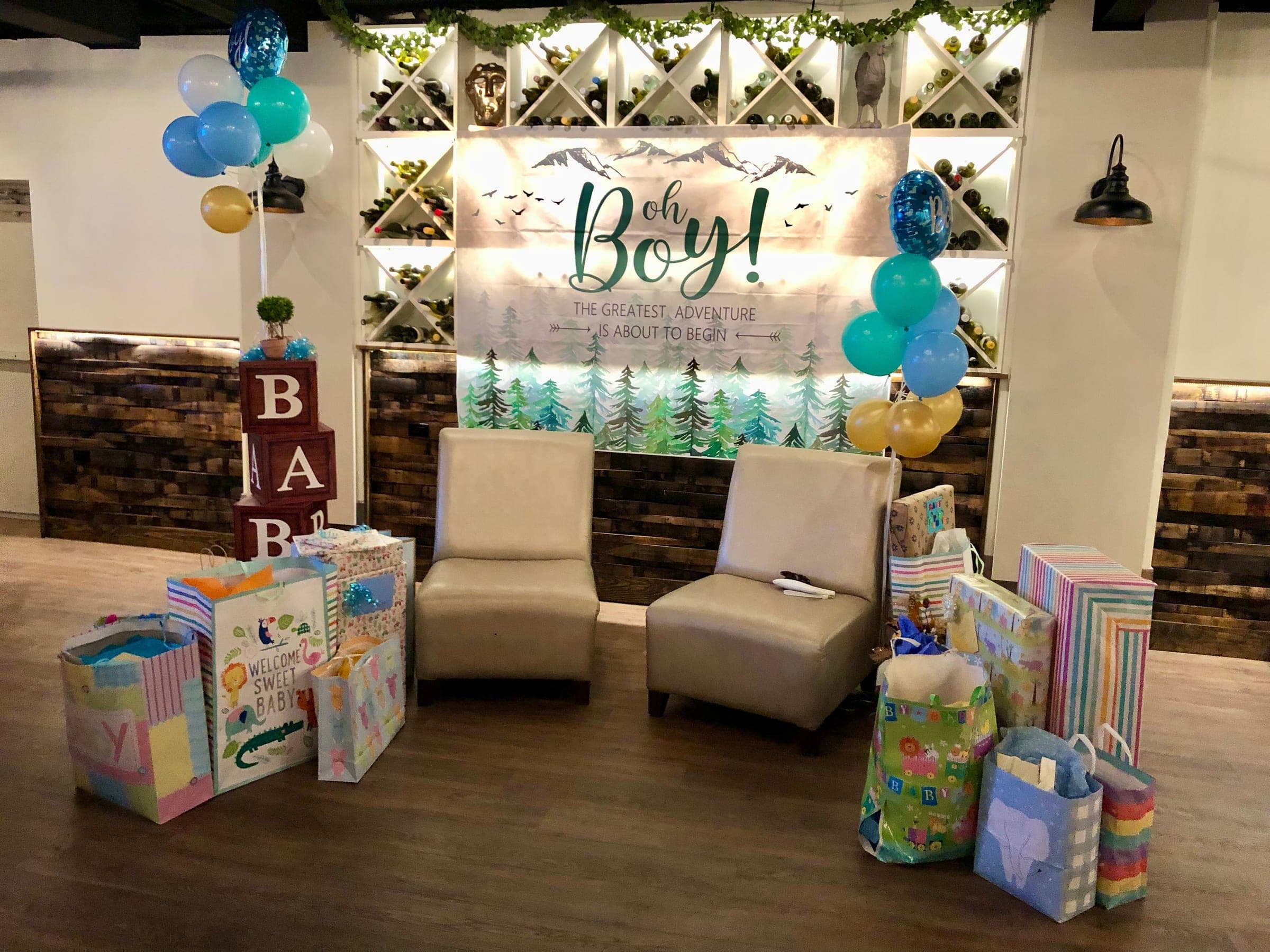 A baby shower in the Wine Cellar at Crown Tavern in Glen Mills, PA, with balloons and a gift table against the wine racks