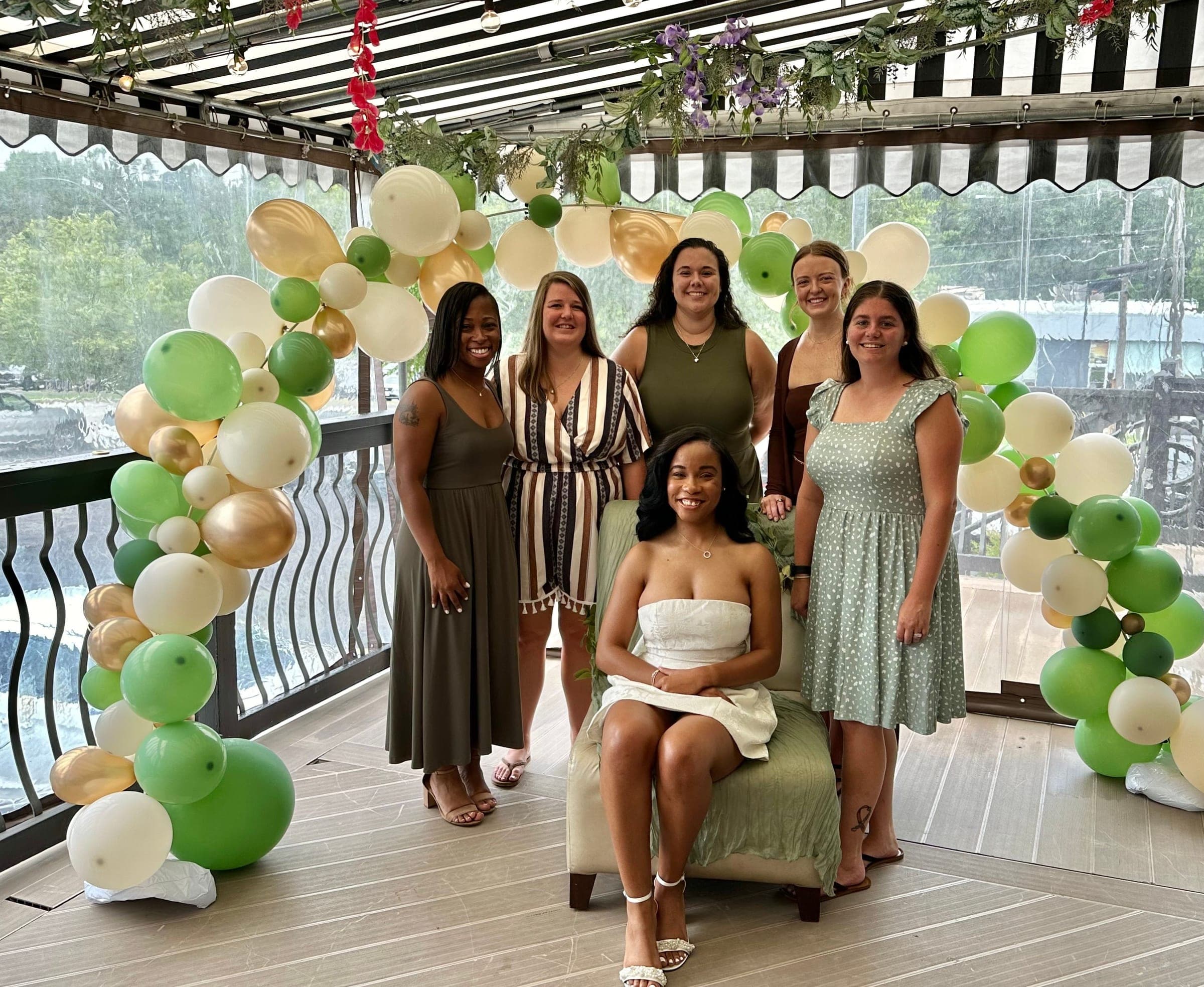 A bride-to-be and her bridal party under a balloon arch on the covered deck at Crown Tavern in Glen Mills, PA