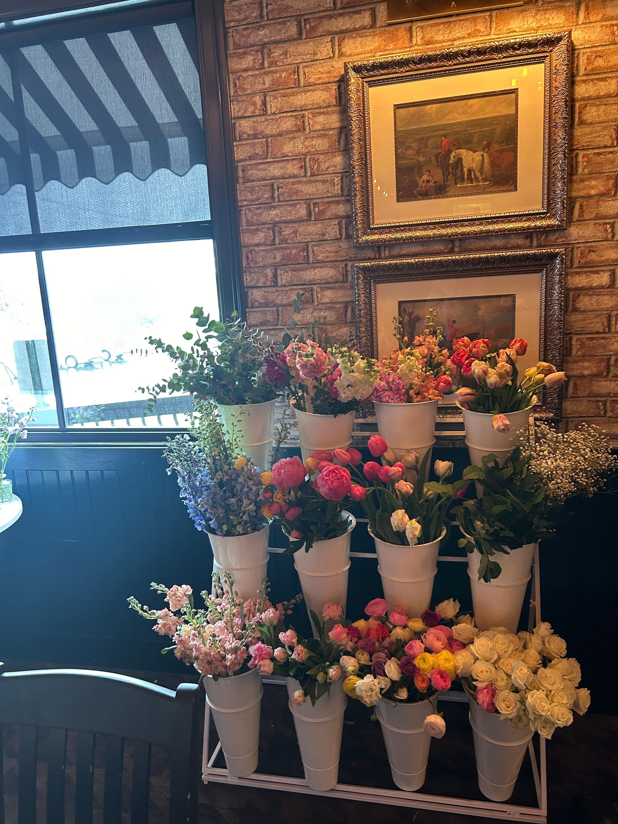 A flower cart of roses, tulips, ranunculus and eucalyptus set for guests to build their own bouquets at a bridal shower at Crown Tavern in Glen Mills, PA
