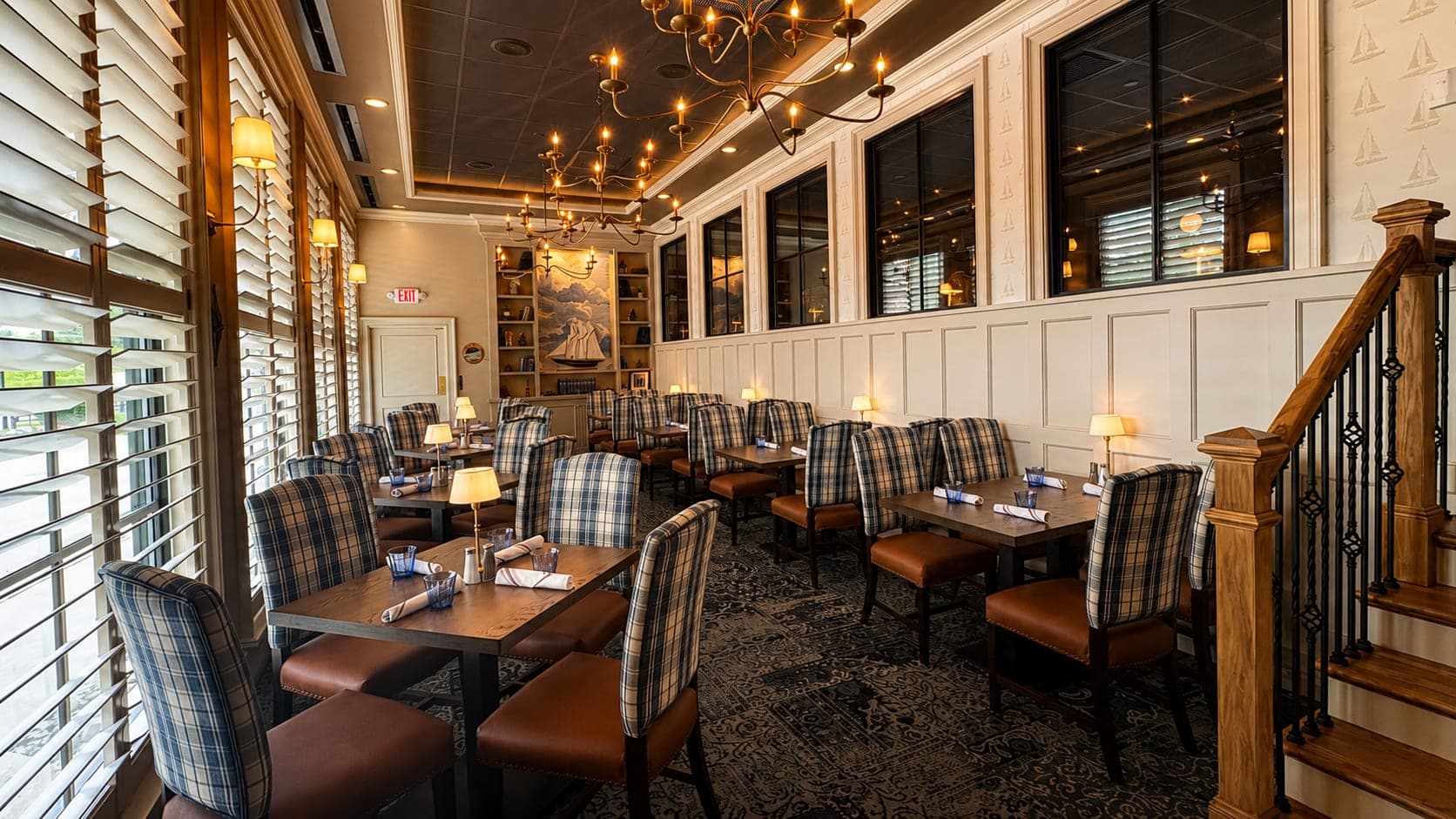 The Britannia Room private dining with tartan chairs, picture windows, and brass chandeliers at Crown Tavern in Glen Mills, PA