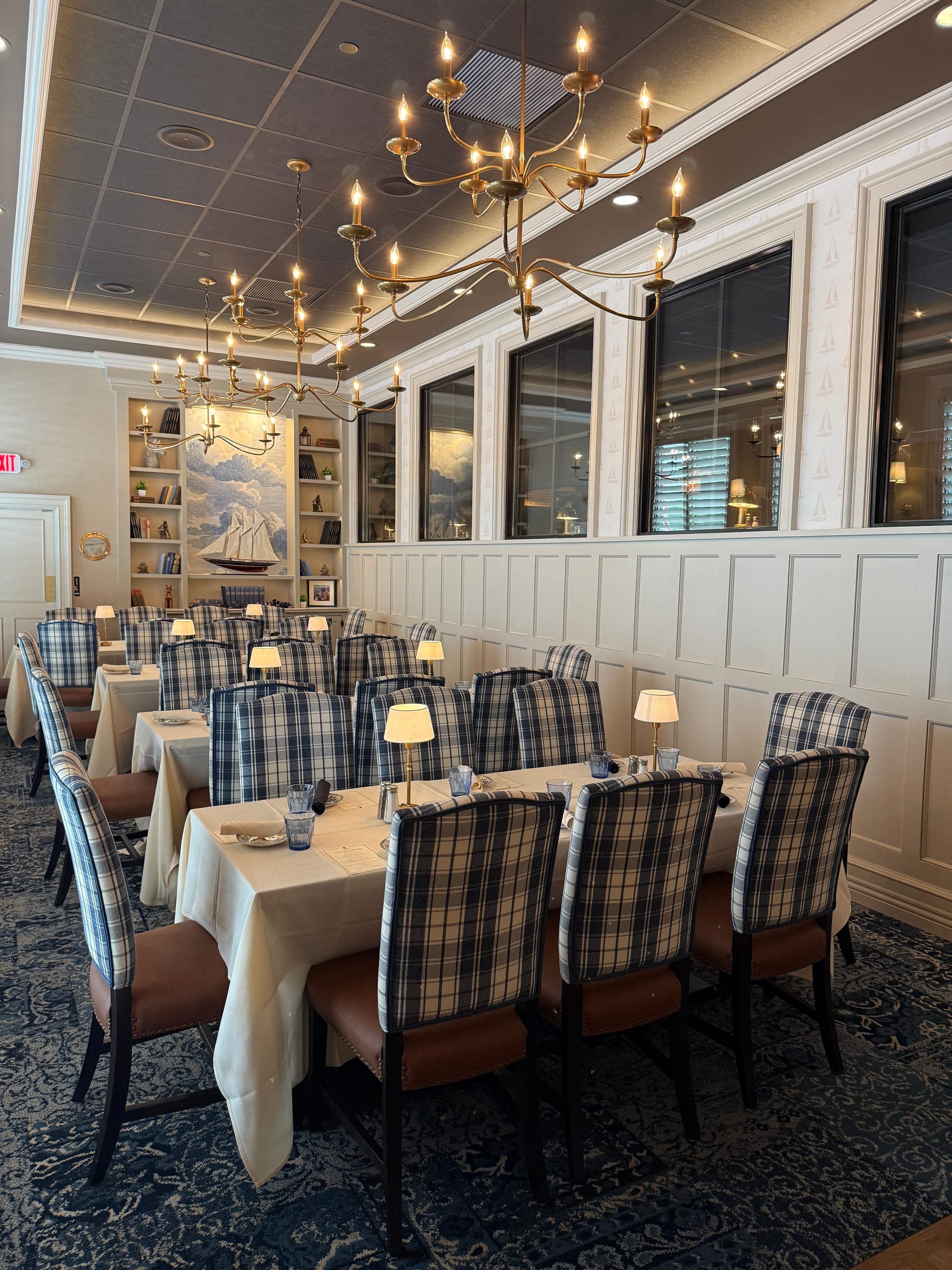 The Britannia Room private dining with tartan chairs, picture windows, and brass chandeliers at Crown Tavern in Glen Mills, PA
