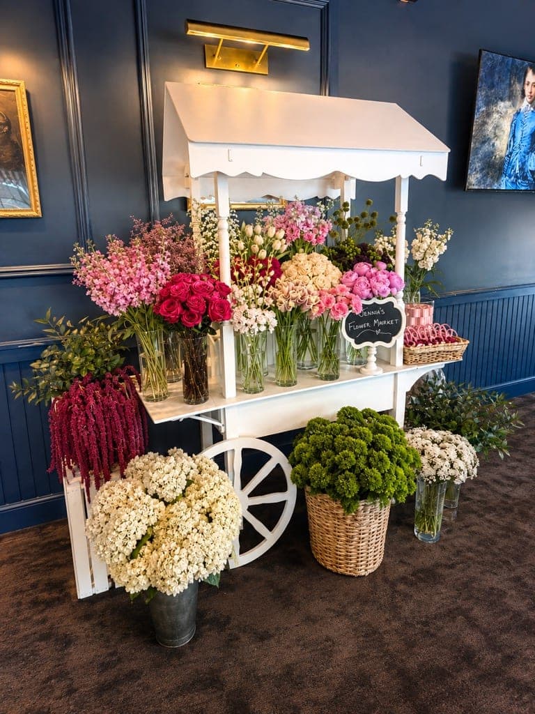 White flower cart filled with roses, hydrangeas and peonies for a bridal shower at The Crown Tavern in Glen Mills, PA