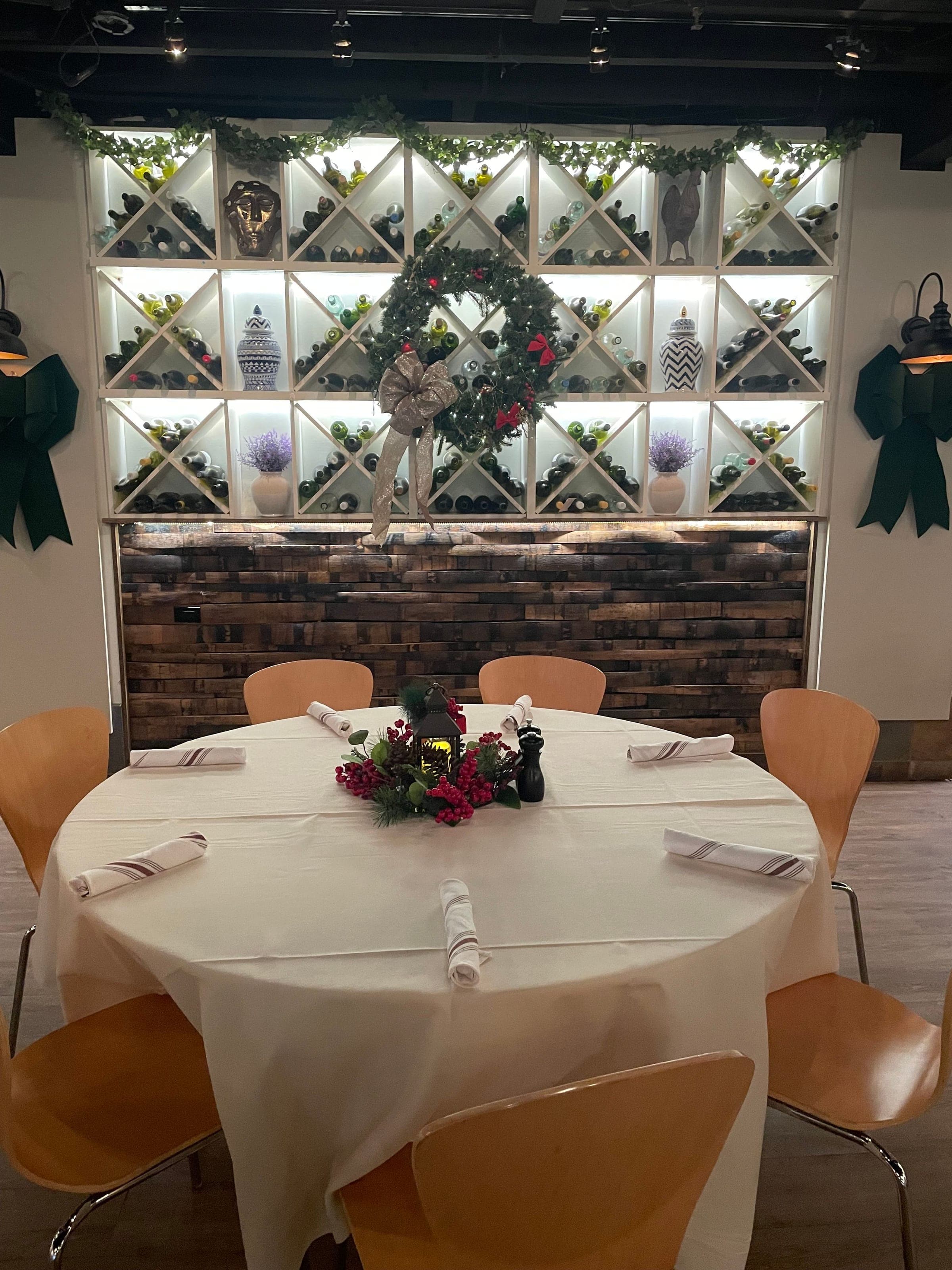 Holiday table setting with a lantern centerpiece and wreath in the Wine Cellar at Crown Tavern, Glen Mills PA